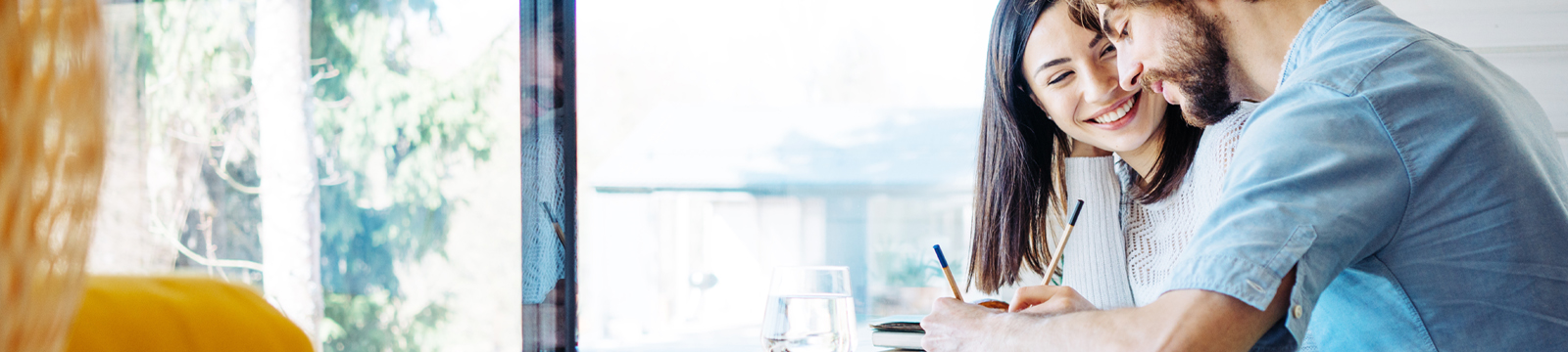 Young couple embracing and looking at financial documents.