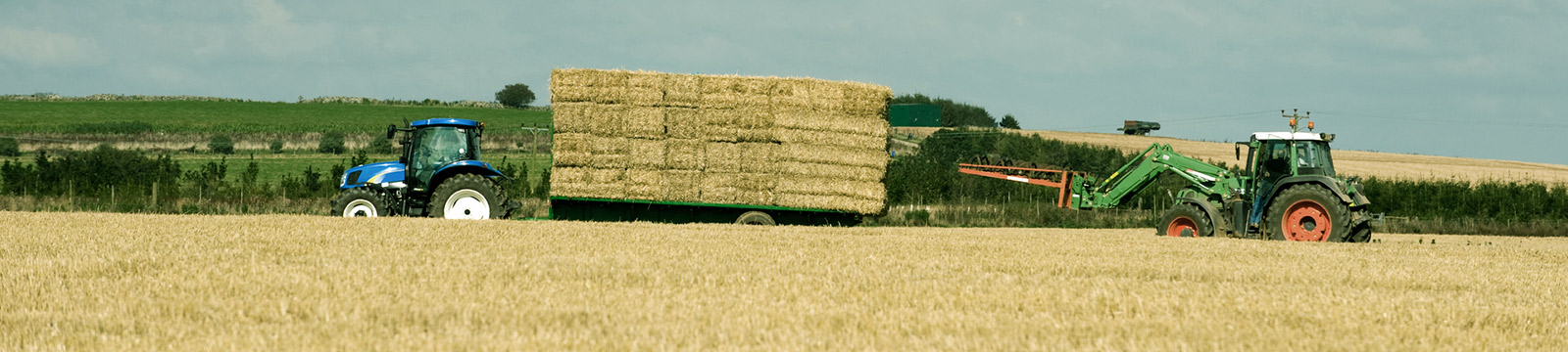 Tractor pulling load of hay.